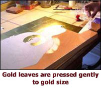 Gold leaves are pressed gently to gold size